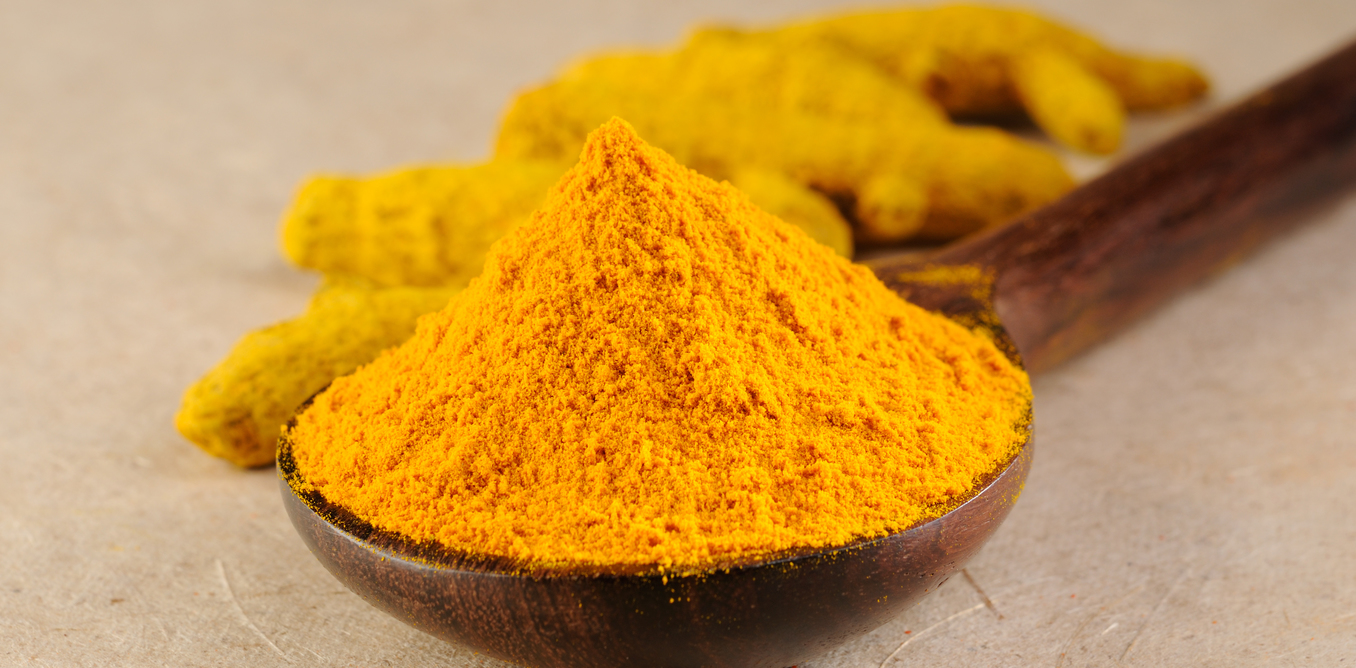 Ground Turmeric in a wooden spoon